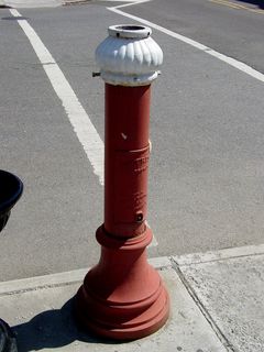 A pedestal, all that remains of one station of an old municipal fire alarm system.  This is all the way across downtown from the fully intact street box that I photographed in 2002.
