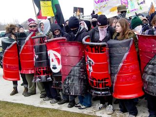 And just like on J27, the shields led the black bloc. We not only had the green "US OUT OF EVERYWHERE" shields from before, but we also had a new set of shields made out of construction barrels painted red and black in the style of the anarcho-syndicalist flag.