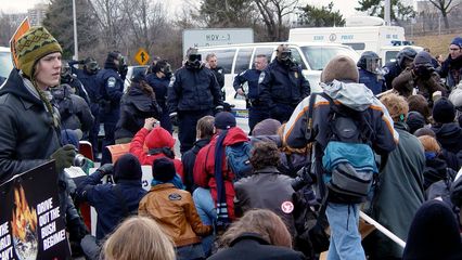 Meanwhile, we were basically at an impasse with the police. Neither side was about to back down. The seated black bloc stood their ground, and the gas-masked cops held theirs.