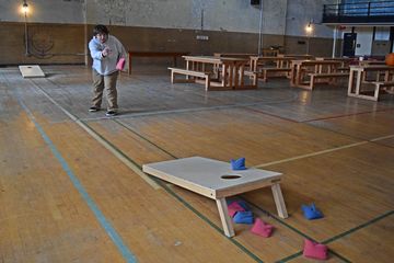 Elyse tries her hand at cornhole on the board that was set up in the gym.