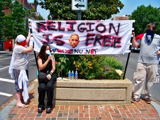 "Religion is free" banner held on the Connecticut Avenue median. The image of Will Smith is included because he and his wife had recently announced that they were going to open a new school that used L. Ron Hubbard's educational methods known as "Study Tech".