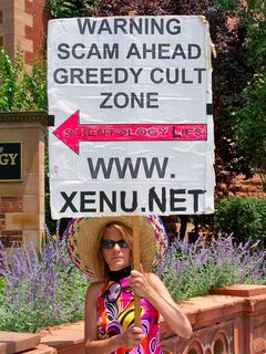 This woman holds a sign with an arrow pointed directly at the Org.