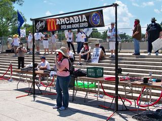 Announcing the "trap contest" on the sound system. The trap contest was essentially an Anonymous spin on a womanless beauty pageant.