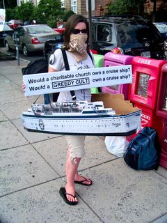 At the flash raid back at the Org, one Anon wears the cruise ship Freewinds while holding a sign questioning why a church would need to own a cruise ship.