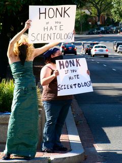 Two Anons stood in the median of Connecticut Avenue encouraging motorists to honk if they opposed Scientology. The wording of these signs, which read "Honk if you hate Scientology" later led Scientology spokesmodel Sylvia Stanard to accuse our group of being a hate group. We really don't hate Scientology or Scientologists, but rather oppose the organization's practices, and as such, we toned down this wording in later raids.