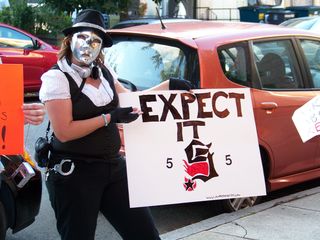 AnonGurl holds up a sign: "EXPECT IT", referring to "Project Five".