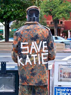 The back of this military-style uniform has "SAVE KATIE" written in tape on the back, referring to Katie Holmes, wife of actor and famed Scientologist Tom Cruise.