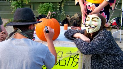 Drawing the Guy Fawkes face on the pumpkin.