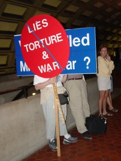 At Rosslyn, I also got my first look at protest signs for this demonstration, as this couple was holding up their signs in the station while waiting for the train.