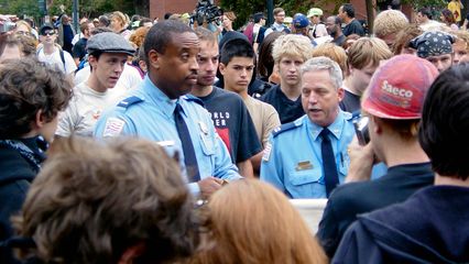 The two uniformed officers, primarily the officer to the right in this photo, explain what's going on.