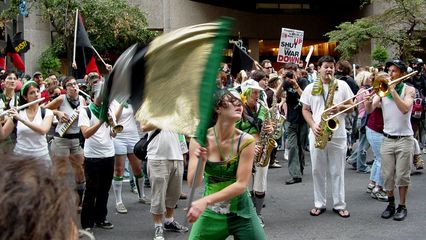 The Rude Mechanical Orchestra takes up their instruments while Becca flies her flag.