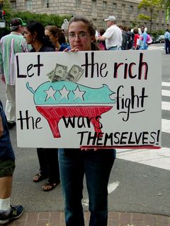 Using money taped to a poster, this person advocates letting the rich fight their own wars.