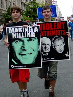 Two people hold up signs indicating who they perceive the real terrorists to be...