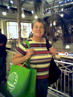 Mom poses for a photo at Pentagon City, carrying a bunch of stuff that she got from the National Book Festival.