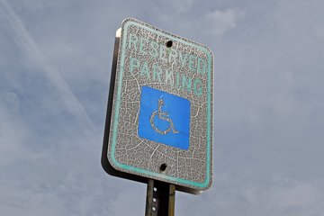 A similarly weathered reserved parking sign.