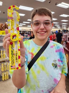Elyse holds up a Buc-ee's toothbrush.