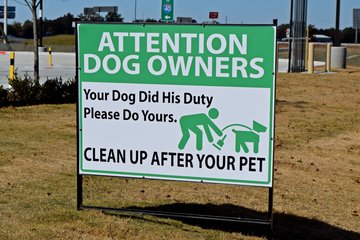 These signs reminding dog owners to clean up after their animals were posted in various places along the outskirts of the property.