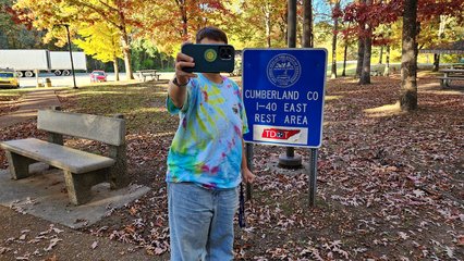 Elyse gets a selfie with a sign at the rest area.