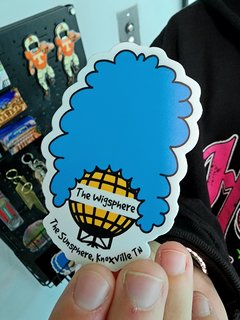 Elyse holds up a "Wigsphere" sticker that was being sold, showing the Sunsphere with Marge Simpson hair.  We ended up buying one of these.