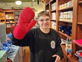 Elyse holds up a red oven mitt.