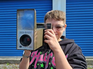 Elyse holds up the Polaroid "Big Shot" camera.