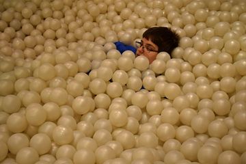 Elyse plays in the ball pit.