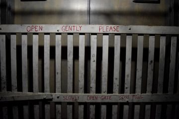 Handwritten markings inside the elevator on the second and third floor gates identifying the floors, as well as a reminder to open the gate slowly and gently - unlike the way that Waldo opened the gate in "Our Story".