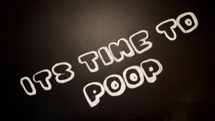 Sign in the bathroom reading, "It's time to poop".
