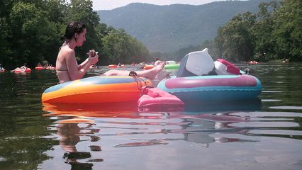 Bethany has lunch while floating in her tube.