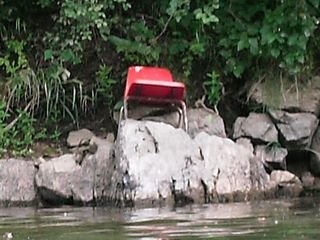 A chair sits discarded along the river. That was one of a few what-the-crap kind of moments, just wondering how such a thing might have managed to get there.