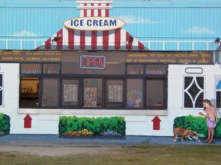 This building, not far from the Ocean Holiday, has quite an interesting paint job. The grass actually reaches all the way up to the building. What looks like a sidewalk is actually painted onto the wall. The bushes are painted on as well. The striped roof and the sky? Also painted on. It definitely makes an interesting impression.