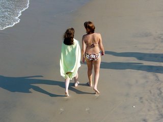 Coming back from the pier, we find some people simply walking the beach near the water, leaving their footprints in the sand behind them.