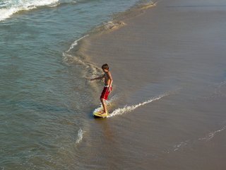 We also find a boy trying to do a little surfing on the waves as they come ashore. Sadly, the waves weren't really sufficient to get some good surfing. The waves were really calm on this trip - noticeably calmer than I'm used to at the ocean.