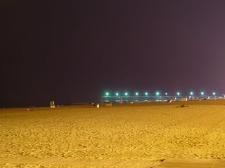 Off in the distance, the fishing pier is lit up in what appears to be a slightly greenish light.