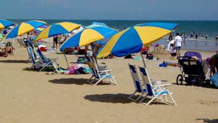 On the beach, I parked in one of those chairs with the umbrellas over them in the photo at left, and took a little dip in the ocean. That was a lot of fun, and it definitely was refreshing. The thing I enjoy about the actual ocean is riding the waves. You can go over the waves, under the waves, let the waves knock you over, let the waves smack against you, dive into the waves... you name it, I probably did it. I enjoy that.