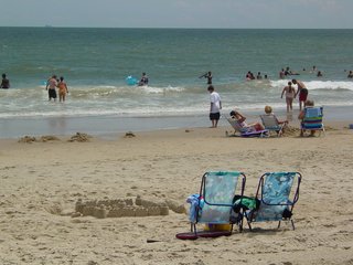 On the beach, I parked in one of those chairs with the umbrellas over them in the photo at left, and took a little dip in the ocean. That was a lot of fun, and it definitely was refreshing. The thing I enjoy about the actual ocean is riding the waves. You can go over the waves, under the waves, let the waves knock you over, let the waves smack against you, dive into the waves... you name it, I probably did it. I enjoy that.