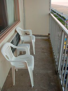 The balcony was a simple affair, with a concrete floor, a railing, and the retrofitted-in sides. The furniture was basically the same as at the Ocean Holiday. Two chairs, and a little table.