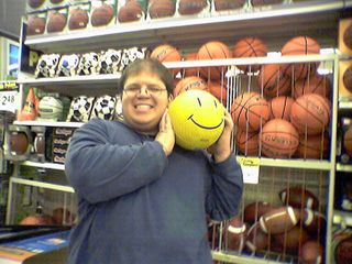 Back in Sporting Goods, Becky took a shot of me holding what I described as "the quintessential Wal-Mart item", a yellow playground ball with the Wal-Mart happy face on it.