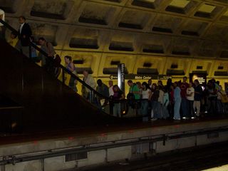 People take the escalator to cross over to the Shady Grove platform in order to catch their Glenmont-bound train.