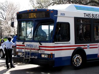 Metrobus displaying "LOCAL" while being used for arrestee transport.