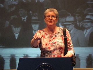 Mom pretends to give a speech from something resembling the White House's "Blue Goose" podium.