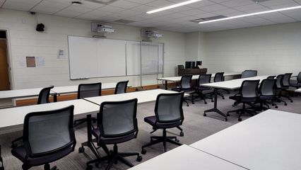 Following renovations, the same room, now numbered 2104 and named for the Bergstrom family and John Marshall Bank, has different lights, a double whiteboard on the front wall only, and, interestingly enough, a carpeted floor.