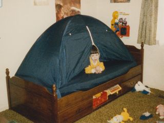 In my room in Rogers, Arkansas (an early view of it in light of the lack of car wallpaper on the left wall), I relax in the bed tent that my parents got me.