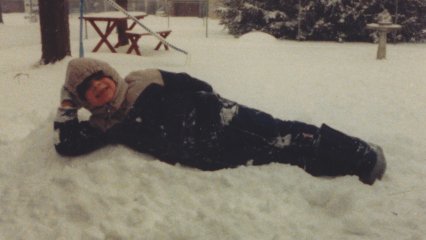 Hamming it up for the camera while laying down on a pile of snow.