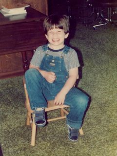 All smiles while sitting on a chair in the family room.