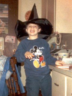 Posing in my Mickey Mouse sweatshirt while wearing a witch's hat, in October 1987. Note the missing tooth that I am sporting in the photo.