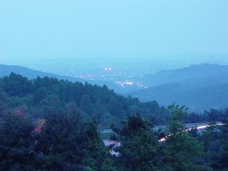 From the mountain above in the early evening, the lights of the nearby city of Waynesboro seem very distant through a slight haze, even though the city is only a few miles away both north and west of Afton Mountain.