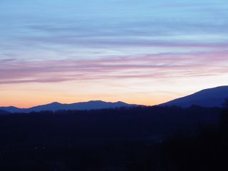 About three miles east of the motel buildings on Afton Mountain, at a scenic overlook on Interstate 64, the sun sets over a partly cloudy sky...