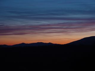 About three miles east of the motel buildings on Afton Mountain, at a scenic overlook on Interstate 64, the sun sets over a partly cloudy sky...