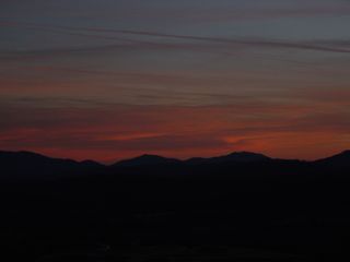 About three miles east of the motel buildings on Afton Mountain, at a scenic overlook on Interstate 64, the sun sets over a partly cloudy sky...